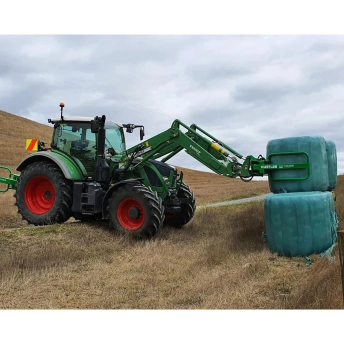 John Deere Tractor picking up a silage bale